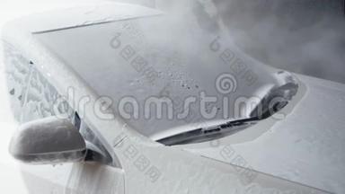 洗车。 泡沫洗涤剂覆盖汽车挡风玻璃，从污垢中清洗。 慢动作